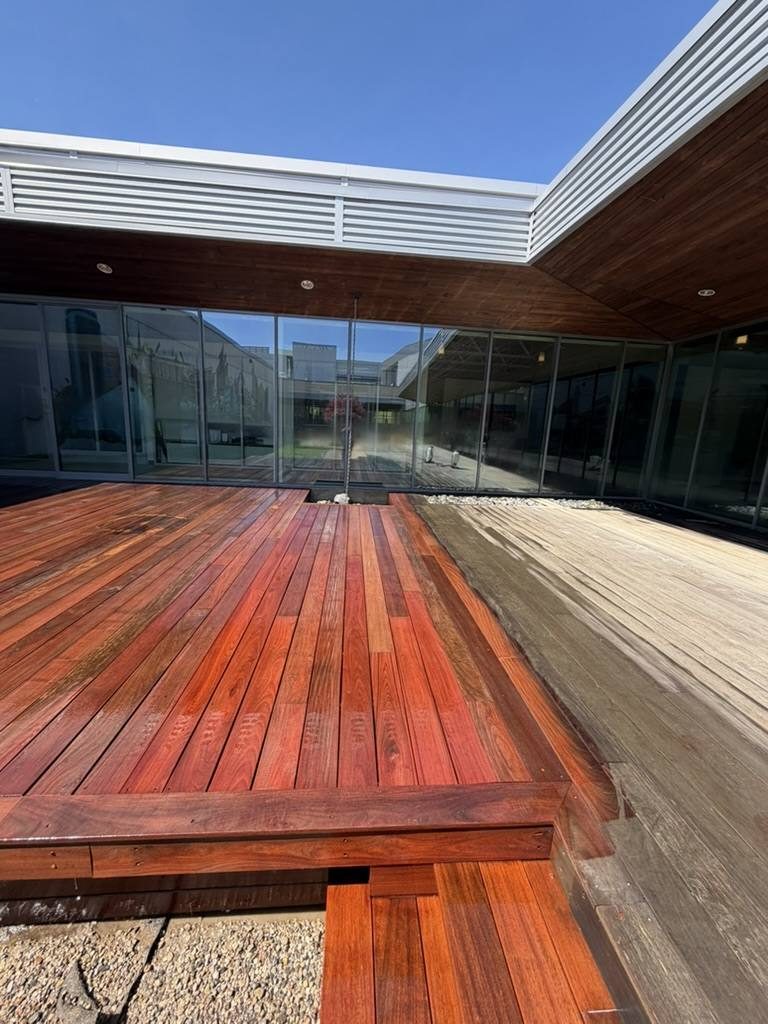 A restored wood deck beside weathered gray boards.