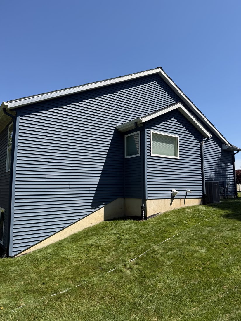 The same elevation after treatment, the siding back to a deep saturated blue.